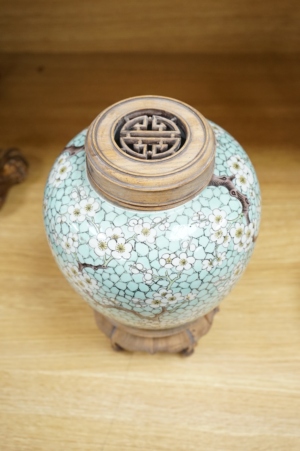 A Chinese famille verte enamelled prunus jar, 19th century, with wood cover and stand, 25cm high
